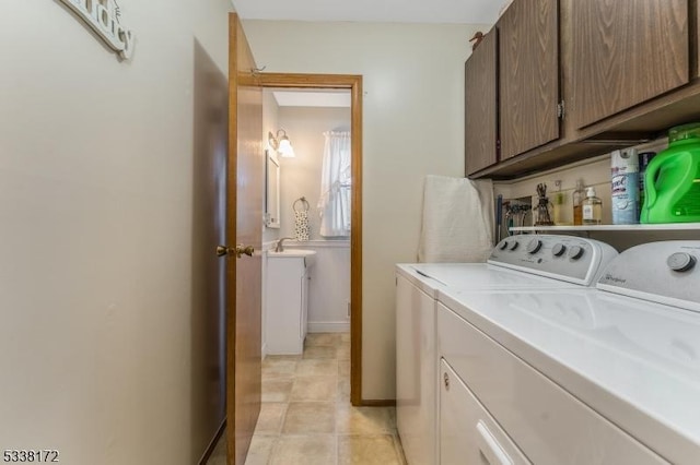 washroom featuring cabinet space, light tile patterned floors, and washer and dryer