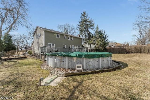 back of property featuring a fenced in pool and a lawn