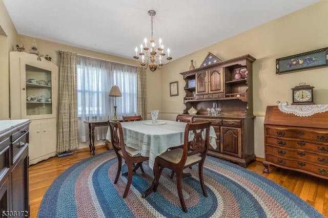 dining room with light wood finished floors and an inviting chandelier