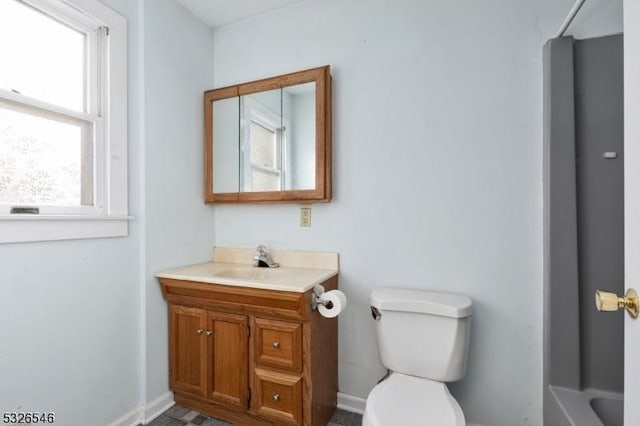 bathroom with vanity, a tub to relax in, and toilet