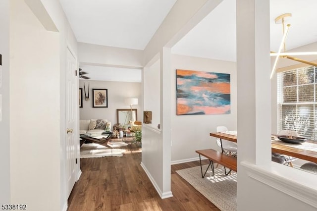 hallway featuring dark wood-style flooring and baseboards