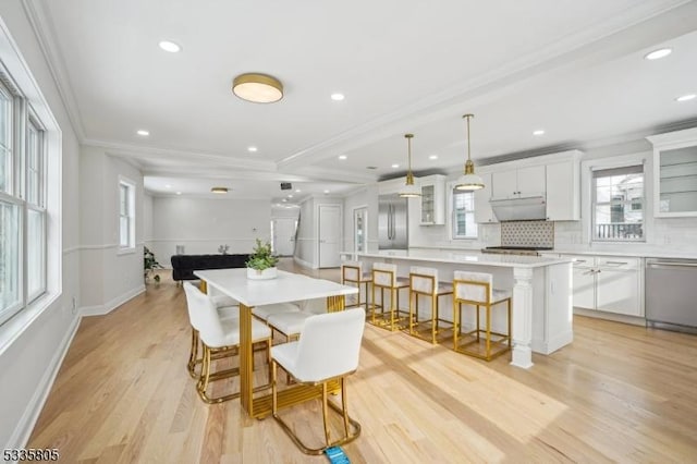 dining space featuring ornamental molding and light wood-type flooring