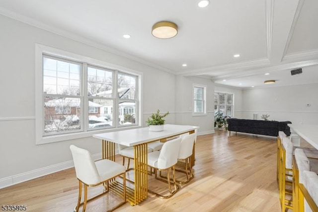 dining room with crown molding and light hardwood / wood-style flooring