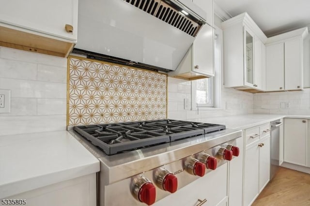 kitchen featuring tasteful backsplash, light hardwood / wood-style flooring, white cabinets, and premium range hood