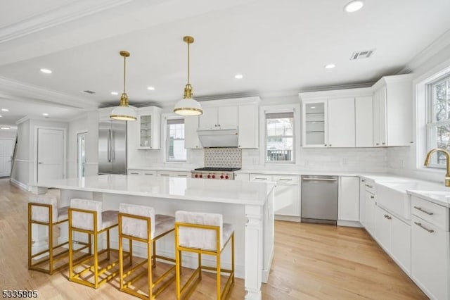 kitchen with sink, white cabinetry, a center island, appliances with stainless steel finishes, and a kitchen breakfast bar