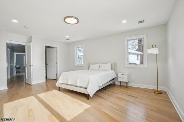 bedroom with multiple windows and light wood-type flooring