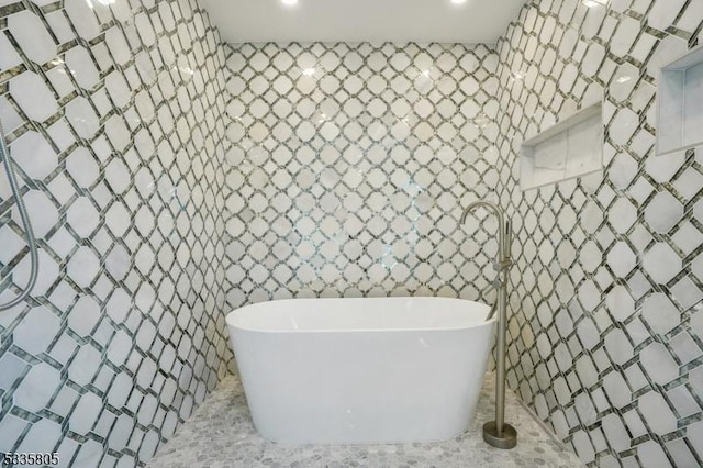 bathroom with tile walls and a washtub