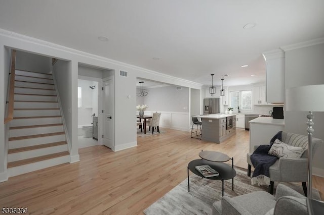 living room featuring ornamental molding and light hardwood / wood-style floors