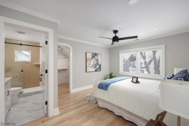 bedroom with ceiling fan, ensuite bathroom, ornamental molding, light hardwood / wood-style floors, and a spacious closet