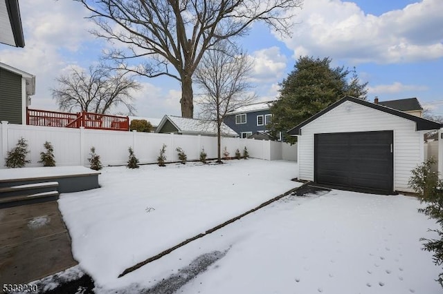 yard layered in snow featuring a garage