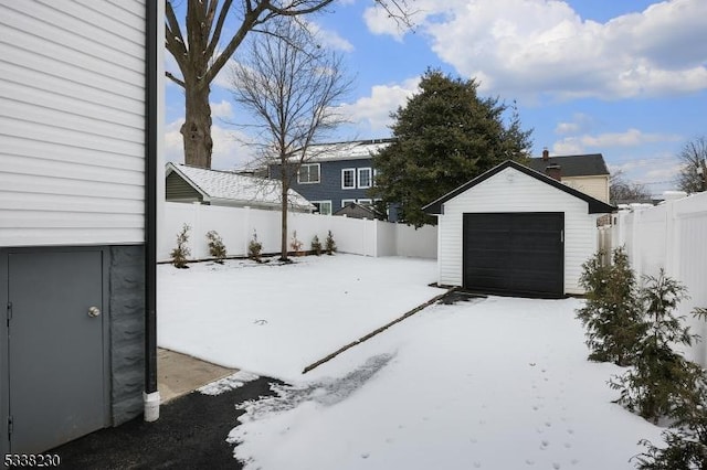 snowy yard with an outbuilding and a garage