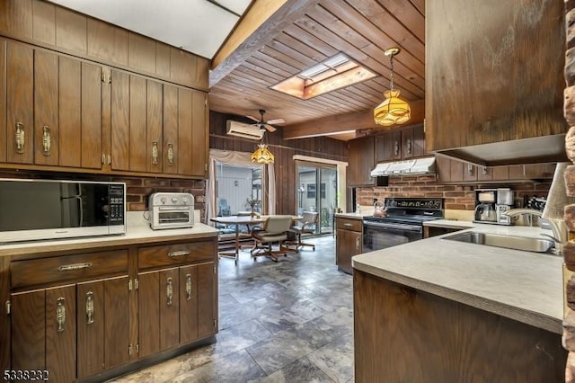 kitchen with black / electric stove, decorative light fixtures, a skylight, and sink