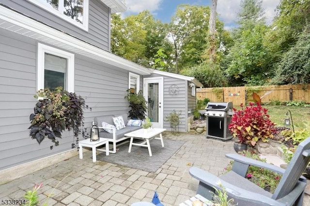 view of patio with an outdoor living space, fence, and grilling area