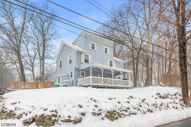 view of front of property with covered porch and fence