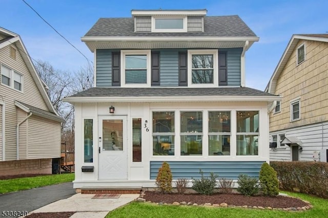 american foursquare style home featuring roof with shingles