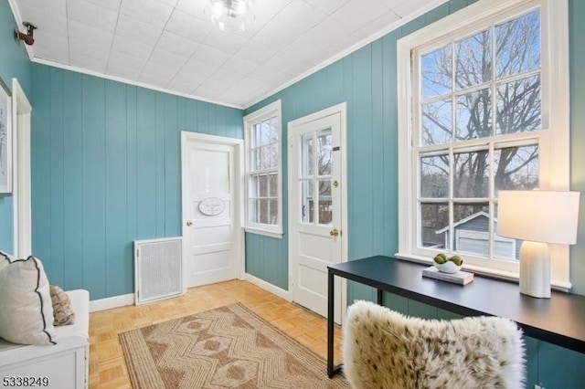 interior space with a wealth of natural light, visible vents, and ornamental molding