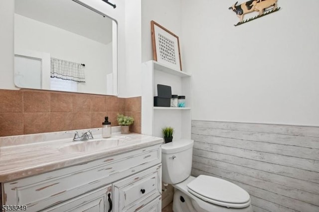 bathroom featuring wainscoting, toilet, and vanity