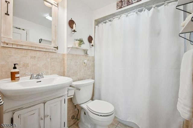 full bath with tile patterned floors, toilet, a shower with shower curtain, tile walls, and vanity