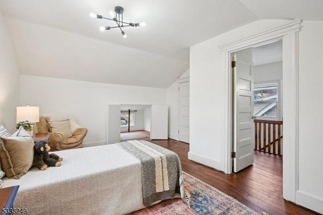 bedroom with vaulted ceiling, multiple windows, wood finished floors, and a chandelier