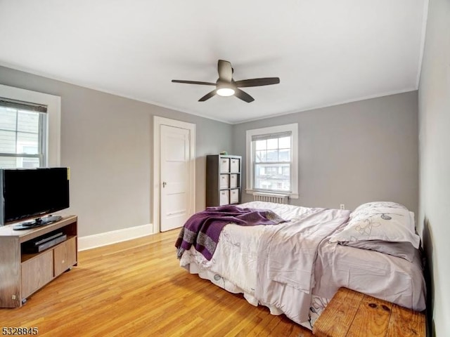 bedroom featuring ceiling fan, ornamental molding, and light hardwood / wood-style flooring