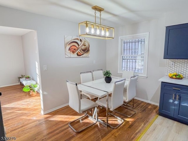 dining area featuring light wood-type flooring and baseboards