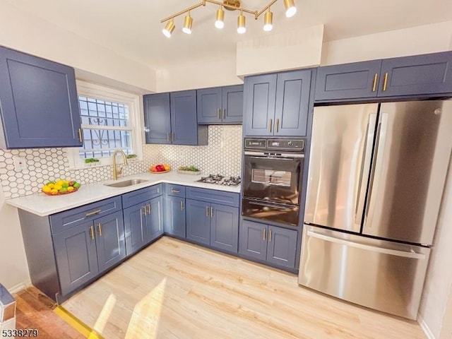 kitchen featuring appliances with stainless steel finishes, light countertops, a warming drawer, and a sink