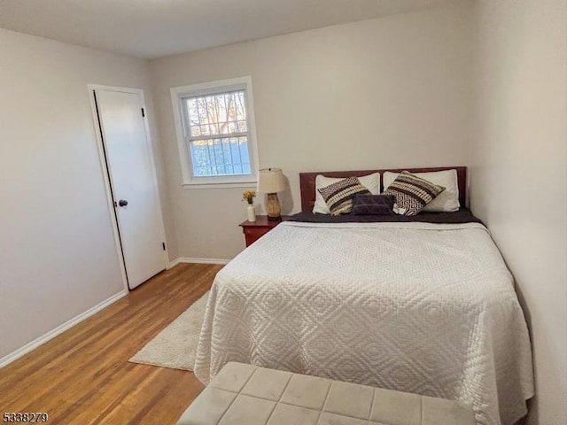 bedroom featuring baseboards and wood finished floors