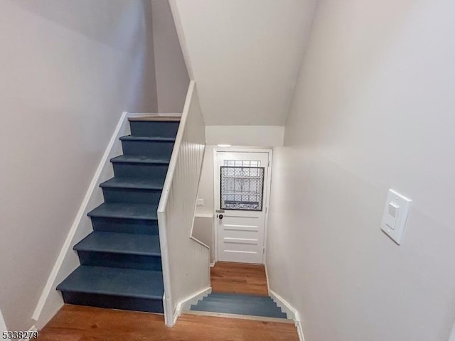 stairs with wood finished floors and baseboards