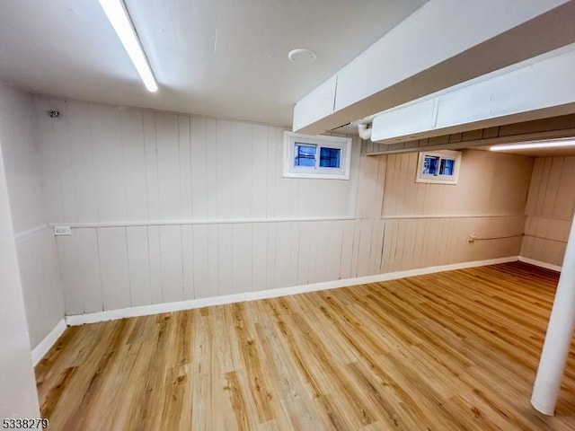 finished basement with baseboards and light wood finished floors