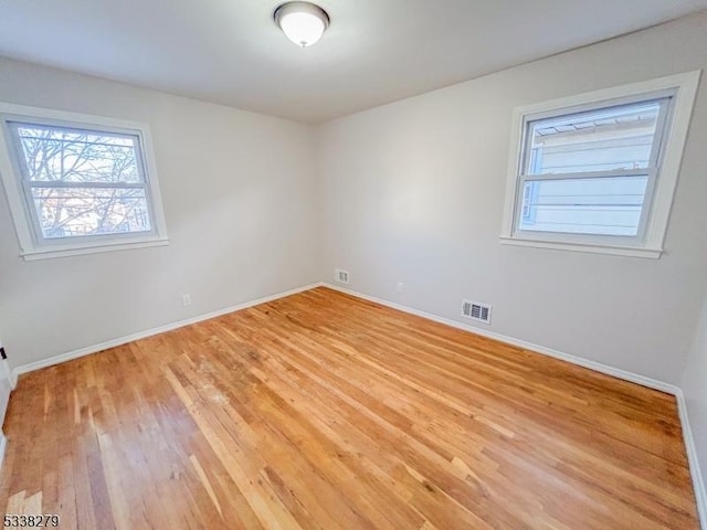 unfurnished room featuring visible vents, baseboards, and light wood-style floors