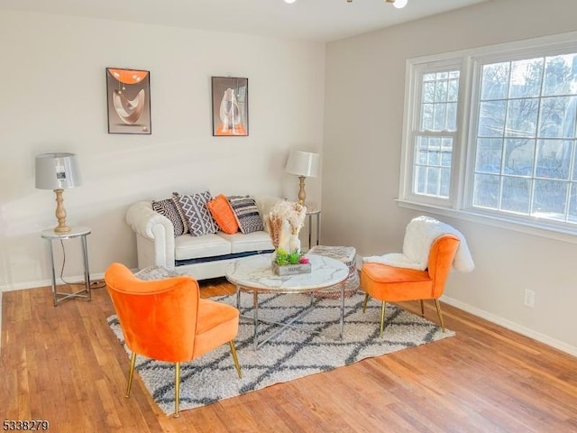 living area with baseboards, plenty of natural light, and wood finished floors