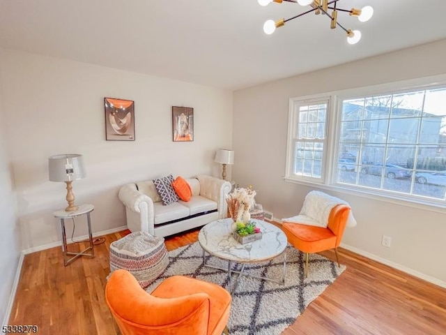 living room with an inviting chandelier, wood finished floors, and baseboards