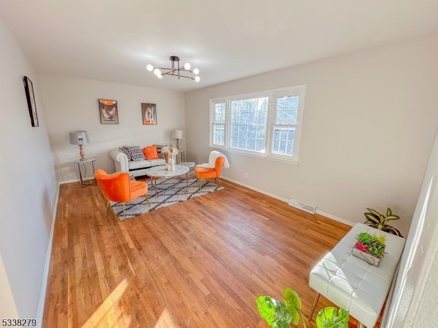 sitting room with visible vents, baseboards, light wood-style flooring, and a chandelier