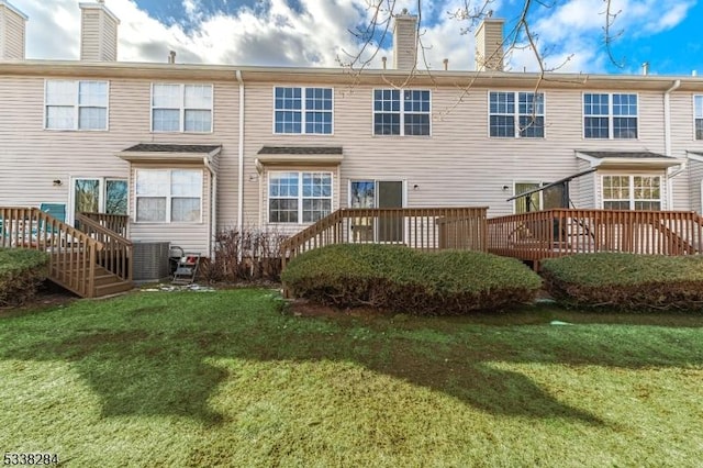 back of house with a deck, central air condition unit, and a yard