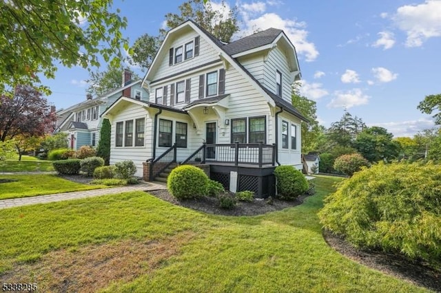 view of front facade with a deck, a front lawn, and a chimney