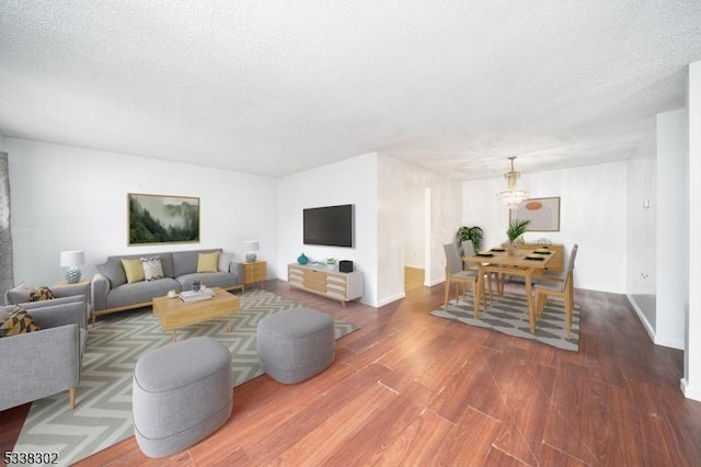 living room featuring a textured ceiling, wood finished floors, and baseboards