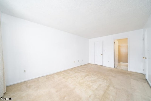 unfurnished bedroom featuring a textured ceiling and light colored carpet