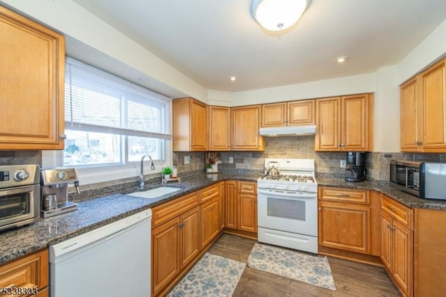 kitchen featuring dark hardwood / wood-style flooring, sink, white appliances, and decorative backsplash