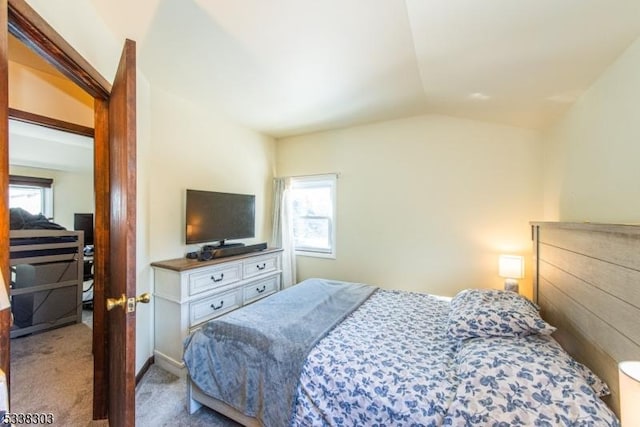 carpeted bedroom with lofted ceiling