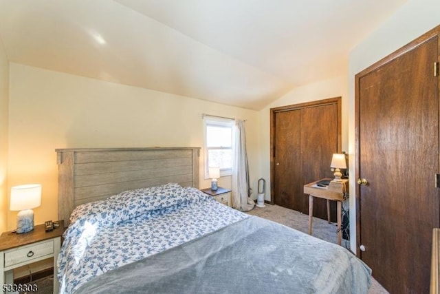 bedroom with light colored carpet, vaulted ceiling, and a closet