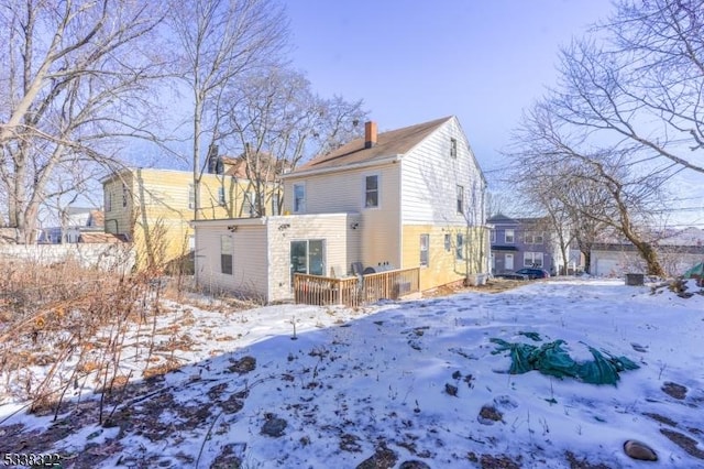 view of snow covered rear of property