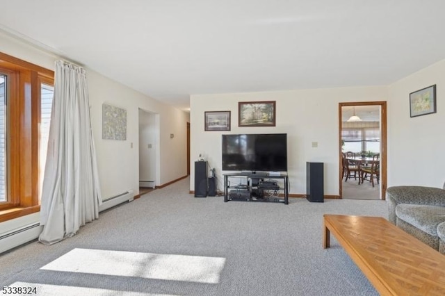 living room featuring a baseboard heating unit, carpet flooring, and a healthy amount of sunlight