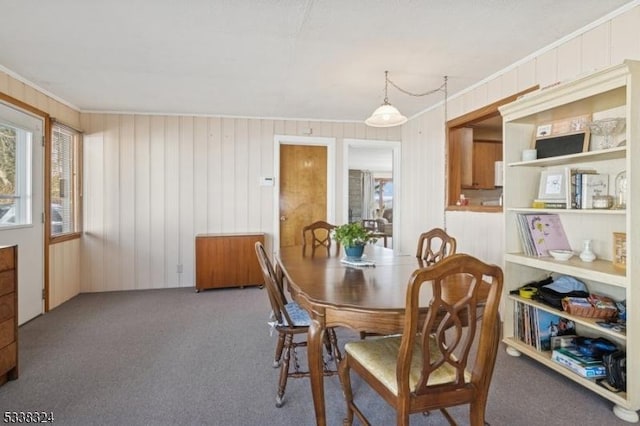 dining area with carpet floors, ornamental molding, and a wealth of natural light