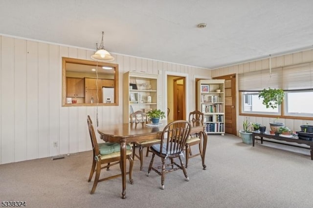 carpeted dining area featuring visible vents