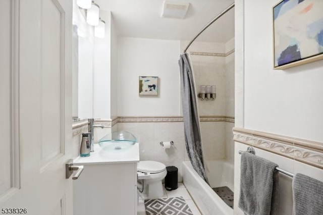 full bath with tile walls, toilet, shower / tub combo, vanity, and tile patterned floors