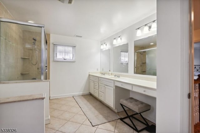 bathroom featuring double vanity, a tile shower, a sink, and tile patterned floors