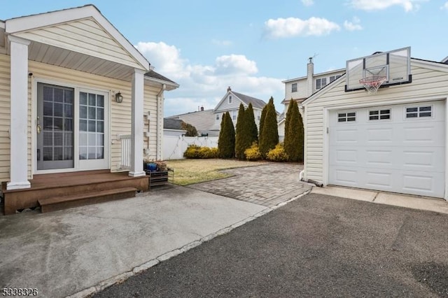 exterior space featuring aphalt driveway and fence