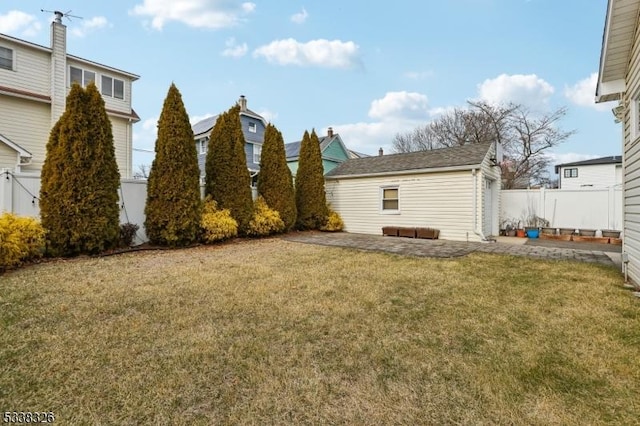 view of yard featuring a patio, an outdoor structure, and a fenced backyard