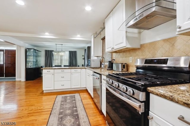 kitchen featuring stainless steel appliances, a peninsula, white cabinets, hanging light fixtures, and ventilation hood