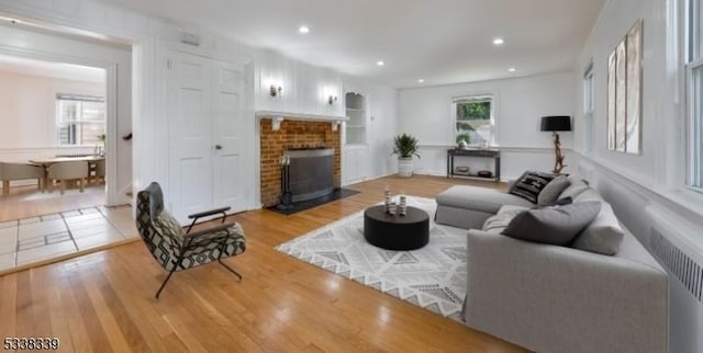 living room with a fireplace, radiator, and hardwood / wood-style floors